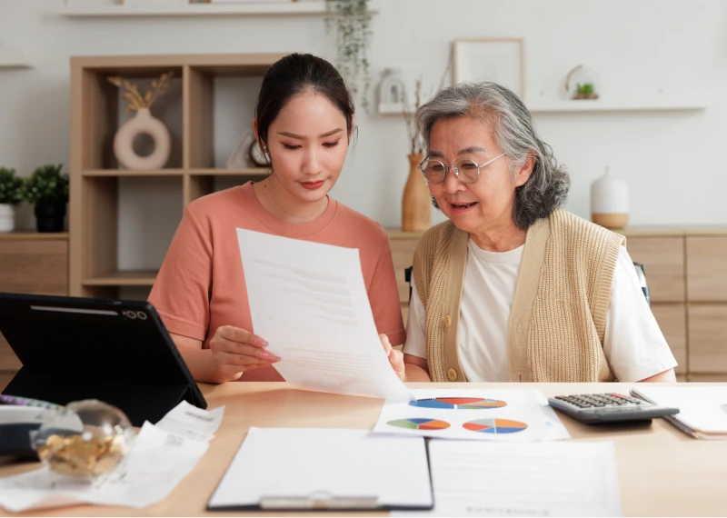 Older and younger woman discussing paperwork