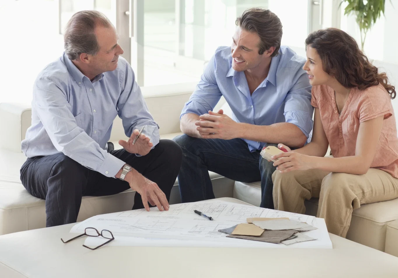 Three people discussing plans on a couch